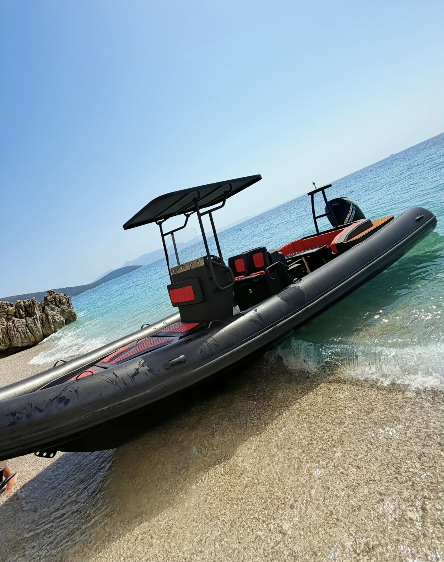 AX Boat Tours Saranda boat on the crystal Ionian waters next to a pristine island